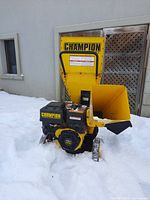 Front view of yellow hopper and black engine in snow