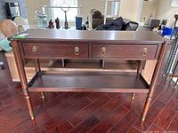 Front view of the wood console table showing drawers and hardware