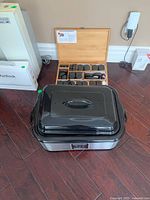 Full view of the massage stone heater closed with the wood box containing 76 stones behind it.