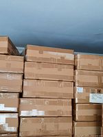 Stack of sealed cardboard boxes containing the spotlights.