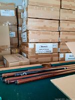 Stacked cardboard boxes labeled 'Westech PAR38 LED Spotlight' and some brown wooden sticks in front.