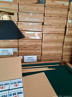 Stacked cardboard boxes of Westech PAR38 LED Spotlight units and open boxes on a green pool table surface.