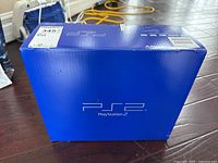 Blue Sony PlayStation 2 retail box on floor
