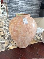 Front view of the stone-look composite decorative vase showing its rounded shape and mosaic tile pattern in pink and beige tones.