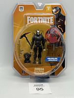 Fortnite Omega 4-inch action figure in original packaging with accessories including pickaxe, shield, backpack, and building materials.