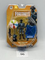 Front view of sealed Fortnite The Visitor Early Game Survival Kit 4 inch figure with accessories in original yellow-orange packaging.