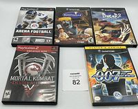 Front view of five game cases: one GameCube game '007 Agent Under Fire' and four PlayStation 2 games including 'Arena Football: Road to Glory,' 'Ratatouille,' 'Dakar 2,' and 'Mortal Kombat Deadly Alliance'.