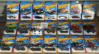 Photo showing all 21 Hot Wheels cars in original packaging arranged in rows, showcasing variety of models and colors.