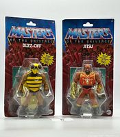 Front view of unopened Masters of the Universe Buzz-Off and Jitsu figures in blister packaging with themed backcard featuring character name and branding.