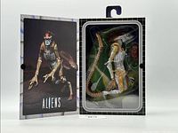 Closed box showing the action figure inside the transparent blister pack along with its accessories. Packaging has Aliens branding and detailed character art on cover.