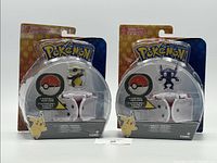 Photo showing both unopened Throw 'N' Pop Poke Ball sets in original packaging with Cubone and Sableye figures visible.