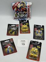 Six Transformers miniature figures shown in original packaging on white surface.