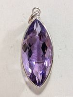 Front view of marquise-cut purple amethyst pendant set in 10K gold with attached bail.