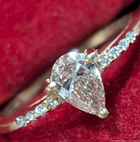 Front top view of ring showing pear shaped lab grown diamond and pavé set round diamonds