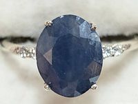 Front close-up view of oval-cut blue sapphire in prong setting