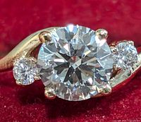 Front view showing round lab-grown center diamond and two side diamonds on polished gold band