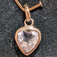 Close-up front view of the heart-shaped pendant showing the faceted moonstone set in 10K gold.