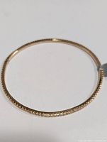 Full view of circular silver bangle bracelet with CZ stones.