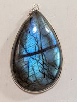 Front view of silver labradorite teardrop pendant showing the iridescent blue hues and natural veining of the stone.