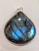 Front view of silver labradorite pendant showing teardrop iridescent stone with blue and gray tones in silver bezel setting.