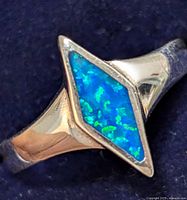 Close-up image of the silver ring showing detailed view of the diamond-shaped opal inlay and marcasite stones set along the border with the polished silver band.