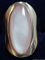 Close-up front view of elongated mother of pearl inlay on polished silver ring band.