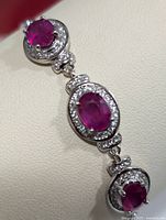 Close-up showing three main ruby stones on the silver bracelet with surrounding cubic zirconia stones.