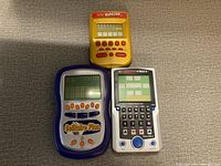 Top view of all three vintage handheld electronic games (Yahtzee, Solitaire Plus, Battleship) showing buttons and display screens.