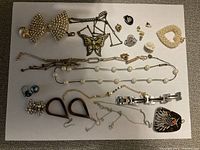 Overhead photo showing all costume jewelry items arranged on paper against dark surface