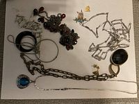 Lot of assorted costume jewelry items including necklaces, bracelets, and earrings laid out on white background.
