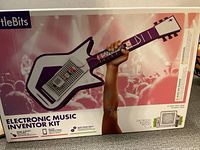 Box front showing the image of the guitar-shaped synthesizer and branding for littleBits Electronic Music Inventor Kit