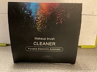 Front of the box showing makeup brush cleaner branding and colorful powder design