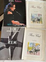 Four music books including Lori Amos MTV Unplugged, R.E.M. Automatic for the People, and two Piano Club sheet music books.