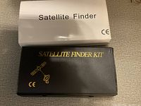White outer box labeled 'Satellite Finder' and black box labeled 'Satellite Finder Kit'