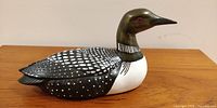 Side view of ceramic loon figurine showing detailed feather patterns and overall shape.