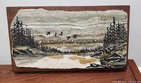 Front view of signed slate painting with nature scene mounted on solid wood panel.