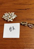 Close-up of the brooch showing gold-tone metal and crystal stones in a floral/starburst design