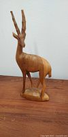 Front view of the teak antelope carving showing detailed horn and body shape.