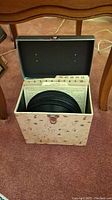 Opened record storage case containing 45rpm vinyl records stored upright with number index tabs.