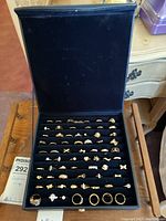 Overview of 69 costume rings displayed in black velvet case showing various styles and designs