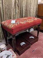 Needlework bench showing upholstery, nailhead trim, and wooden turned legs.