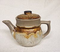 Front-right view of Laurentian Tundra handmade pottery teapot with signature lava drip glaze finish and rounded body shape.