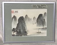 Full view of framed Shan Shui ink painting on rice paper with mountains, boats, birds, and chop seal.