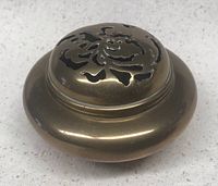 Incense burner with vented lid showing floral cut-out design on top