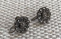 Close-up photo of the front view of sterling silver earrings with ornate marcasite designs showing pattern and lever back clasps.