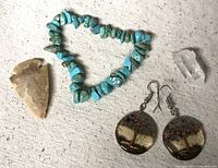 All items of the lot shown together: turquoise bracelet, crystal cluster, Tree of Life earrings, arrowhead.