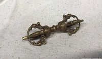 Side view of vintage Tibetan brass Vajra showing detailed design