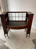 Front view showing curved desktop, glazed mullion glass back and side shelves