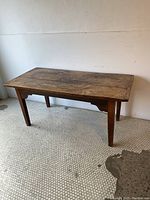 Full front view of the plank-top table with scalloped apron and straight legs