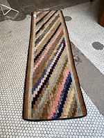 Full top view of the hooked zigzag runner showing the overall geometric pattern and colors on a hex tile floor.